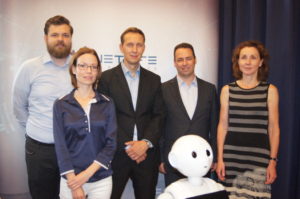 Csapatunk tagjai és természetesen Pepper a humanoid robot, aki kicsit elvarázsolt módon kifele fordult. A digitalizált ügyfélkiszolgálás szakértői vagyunk.